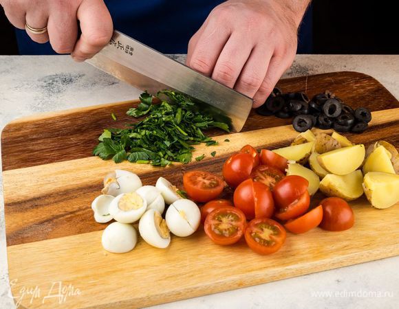 Картофель отварите и нарежьте четвертинками. Отварите вкрутую перепелиные яйца и нарежьте на половинки. Помидоры черри нарежьте на половинки, маслины нарежьте кружочками, петрушку порубите мелко.
