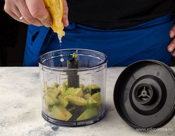 Сложите кусочки авокадо в блендер и сбрызните соком лимона. Измельчить авокадо с помощью блендера.