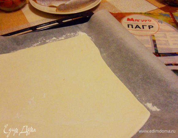 Раскатать лист слоеного теста. Присыпать мукой и выложить на противень.