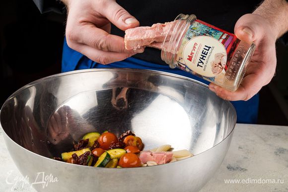 В салатник выложите поджаренные цукини с луком, разрезанные пополам томаты черри, готовую пасту. Тунца ТМ «Магуро» добавьте в салат сверху на овощи и слегка разомните вилкой.