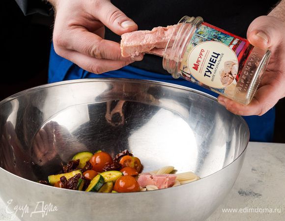 В салатник выложите поджаренные цукини с луком, разрезанные пополам томаты черри, готовую пасту. Тунца ТМ «Магуро» добавьте в салат сверху на овощи и слегка разомните вилкой.