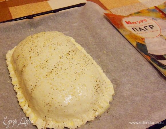 Смазать кулебяку, присыпать черным молотым перцем и кунжутом. Выпекать в духовке при температуре 200°С до готовности рыбы и появления золотистой корочки на тесте.