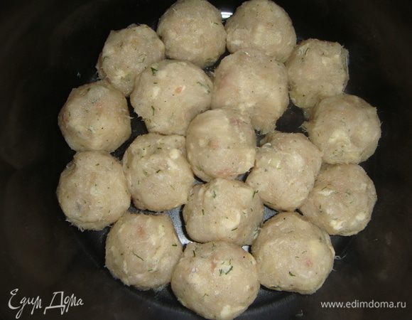 В форму для запекания влить чесночное масло, распределить его по дну. Из фарша сформировать фрикадельки и уложить в форму.