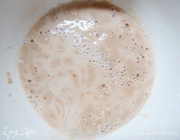 Дрожжи развести в 100 мл теплой воды. Дождаться появления дрожжевой шапочки (на это требуется обычно минут 10-15).