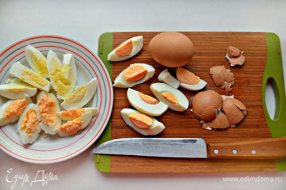 Яйца отварите вкрутую, охладите, очистите и нарежьте дольками на 6 частей.