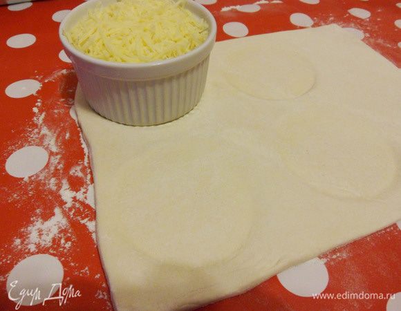Посыпать стол мукой. Раскатываем слоеное тесто. Разрезаем тесто на четыре части по формочкам.