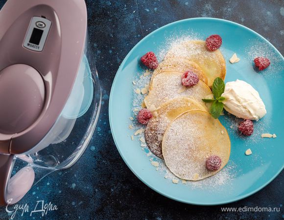 Выложите блинчики на плоскую тарелку, смажьте сливочным маслом и добавьте в середину несколько ягод малины. Подавайте со сметаной. 
Для приготовления этого вкусного завтрака мы использовали воду из фильтра-кувшина BRITA Marella Pastel.
