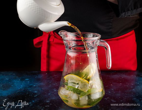 Вторую часть лимона порежьте тонкими ломтиками. Добавьте в кувшин мед, мяту и лед и залейте чаем.