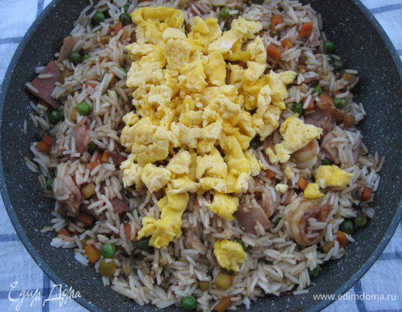 Добавить отварной рис и кусочки омлета, перемешать, дать рису прогреться. Снять с огня.