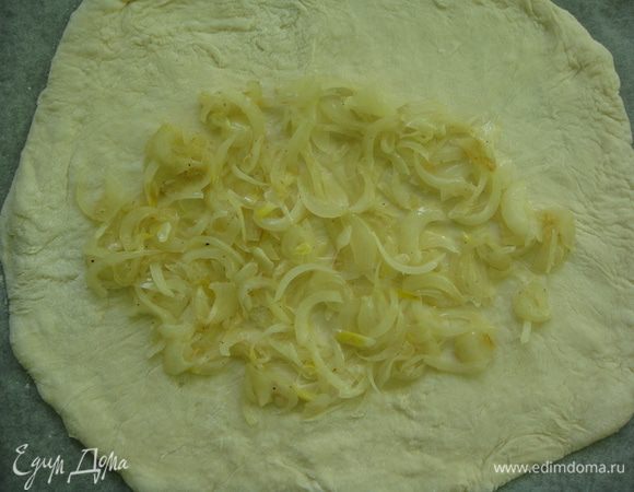 На середину теста выкладываем обжаренный репчатый лук.