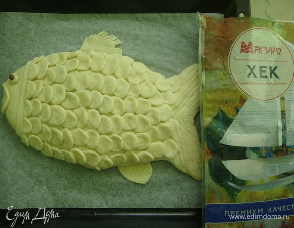 Из остатков оформляем голову рыбке, делаем глаз и губы. В глаз можно воткнуть горошинку черного перца. Оставляем пирог на 20 минут в теплом месте.