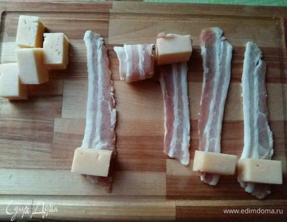 Каждый ломтик сыра обернем в бекон, и скрепим зубочистками.