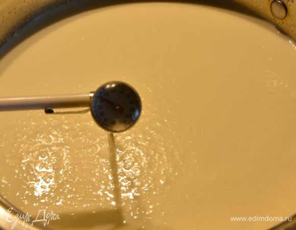 Подогреть массу до 32°С. Добавить воду с сычужным ферментом, перемешать 30 секунд. Прикрыть крышкой и оставить в тепле на 10-15 минут.