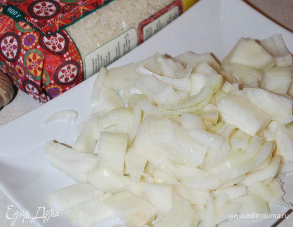 Пока мясо жарится, режем лук. Лук не обязательно резать мелко, он весь ужарится, и в готовом плове его не будет видно.