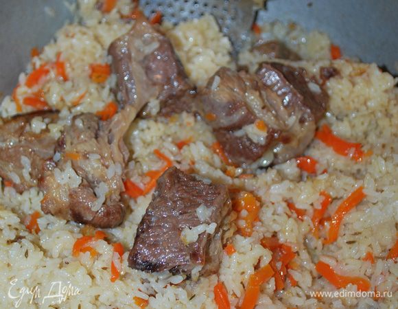 Готовый плов перемешиваем. Выкладываем на тарелку, сверху кладем мясо.