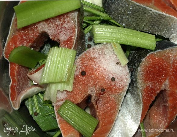 В кастрюлю складываем лук, стебли петрушки, сверху выкладываем рыбу. Добавляем один стебель сельдерея, соль, перец горошком. Заливаем 2 литрами воды и на медленном огне доводим до кипения. Варим до готовности репчатого лука.  