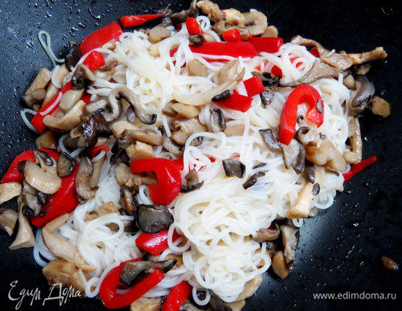 Рисовую лапшу отвариваем согласно инструкции на упаковке.  Затем добавляем лапшу к грибам и перцу, жарим 3-4 минуты.