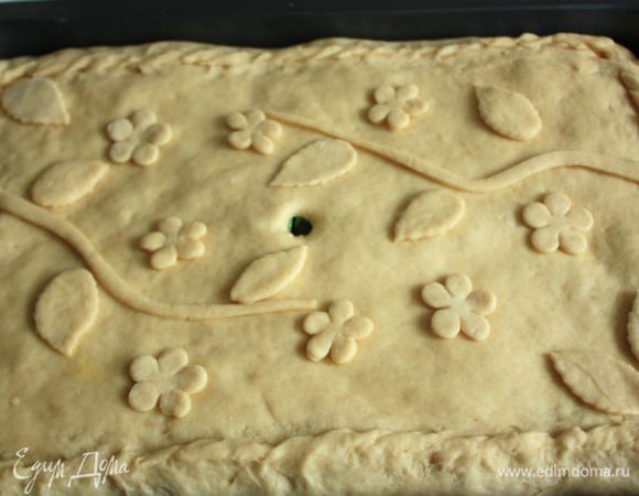 Оставшееся тесто раскатать, накрыть им начинку, соединить плотно края. В середине сделать отверстие для пара. При желании можно украсить поверхность пирога (произвольно). Поскольку на Троицу принято было украшать дом ветками березы, цветами, богородской травой, то я решила тоже использовать растительную тему, приклеивая фигурки вторым взбитым яйцом. Накрыть пирог салфеткой и дать ему подойти в течении 20-30 минут. Разогреть духовку до 180°С. Перед выпечкой смазать пирог взбитым яйцом. Выпекать примерно 30 минут до золотистого цвета.