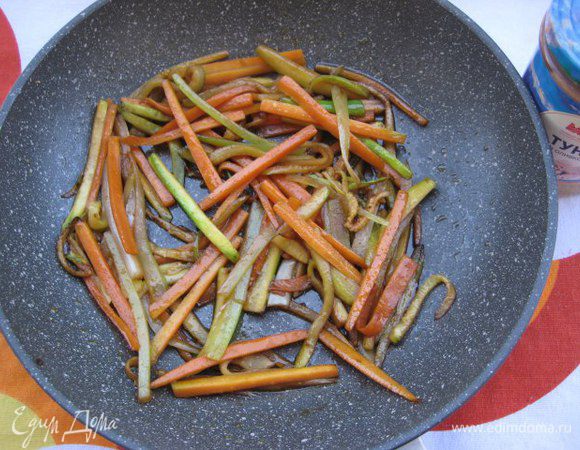 Разогреть в сковороде кунжутное масло, на сильном огне обжарить овощи с зубчиком чеснока в течении 3 минут, интенсивно помешивая. Чеснок выбросить. Добавить специи, соевый соус, перемешать и снять с огня.