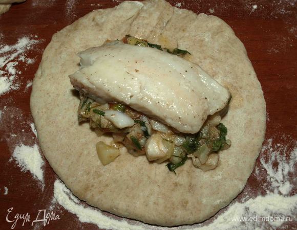 Из теста формируем лепешки. В середину выкладываем начинку с картофелем. Сверху кладем целый кусок рыбы. 