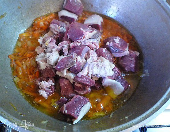 Мясо нарезаем небольшими кусочками и добавляем в казан к луку и моркови, все перемешиваем и готовим на среднем огне еще 10 минут. Крышкой казан не накрываем.