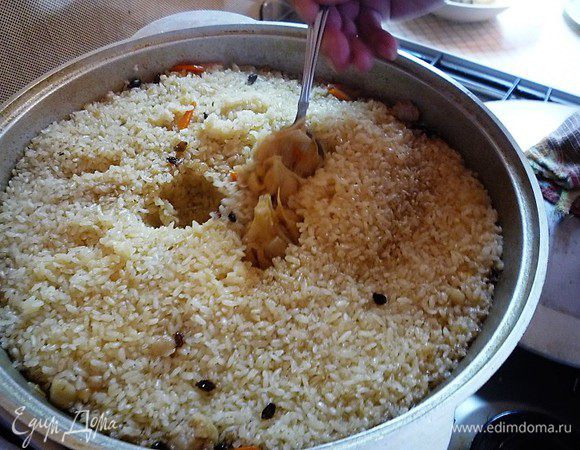 Плов готов! Извлекаем чеснок и перемешиваем плов шумовкой снизу вверх.