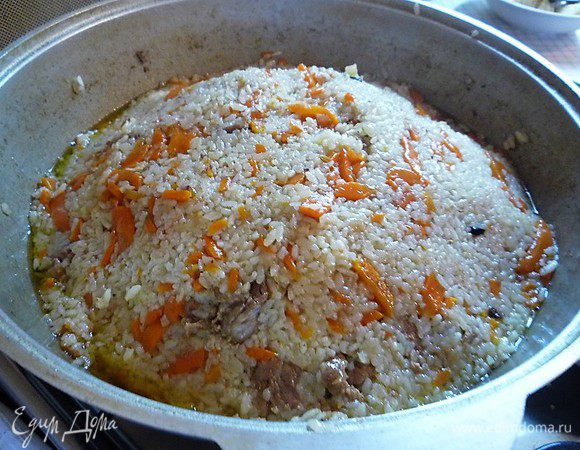 Формируем горку, накрываем крышкой, даем настояться и подаем на стол. Плов необходимо подавать с солеными огурцами, помидорами или перцем.