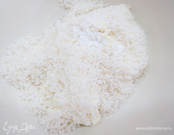 Творог для этих конфеток лучше брать без крупинок, если творог крупинчатый, пробить блендером или протереть через сито. Творог положить в миску, добавить пудру и 50 г кокосовой стружки. Количество пудры можно регулировать по своему вкусу в зависимости от желаемой степени сладости. Все ингредиенты перемешать, отставить минут на 10-15.