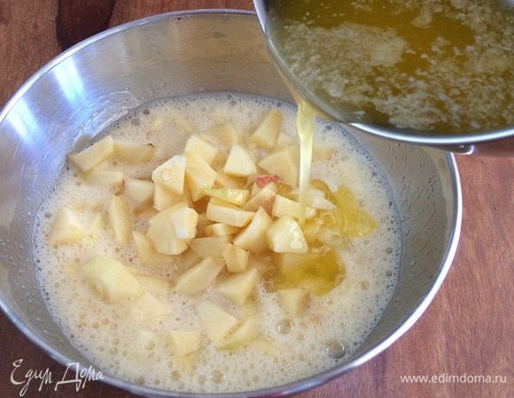 Выложить яблоки к сахару и яйцам. Влить струйкой сливочное масло, постоянно помешивая.