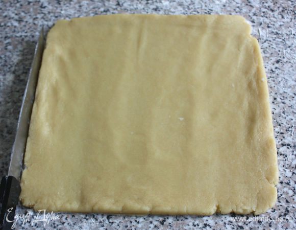 Прямоугольную разъемную форму 22х22 см или прямоугольную 12х35, или круглую диаметром 24 см смазать маслом. Охлажденное тесто раскатать в пласт, выложить в форму, хорошо прижать руками ко дну и бортикам, лишнее обрезать. Дно наколоть вилкой.