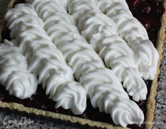 Пирог вынуть из духовки. Поверх вишни выложить спирально взбитые белки из кондитерского мешка или распределить ложкой, формируя волны.