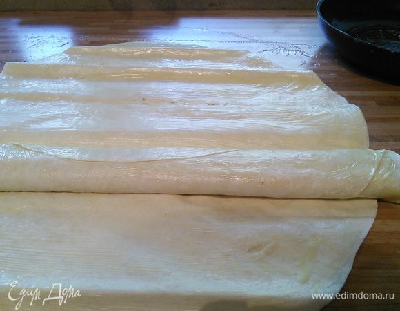 Таким образом скрутите 3 рулета с ореховой начинкой. Один из них все-таки придется плотно скрутить змейкой, он будет ломаться, но в конечном итоге это не будет заметно. Этот рулет будет серединкой пирога. Выложите его на противень, покрытый пекарской бумагой.