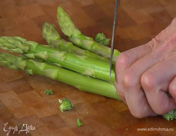 Спаржу, удалив грубые черенки, разрезать пополам.