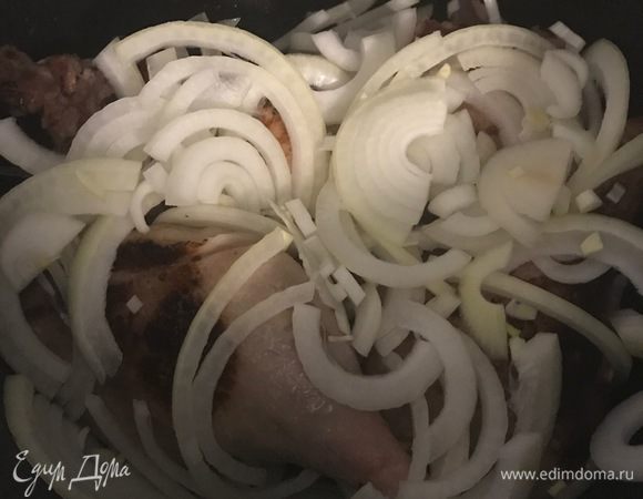 В сковороду добавьте оливковое масло. Обжарьте ножки до золотистой корочки. Добавьте нарезанные лук и чеснок. Пусть жарится пару минут.