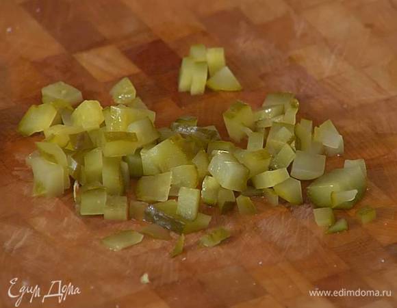 Маринованный огурец нарезать маленькими кубиками.