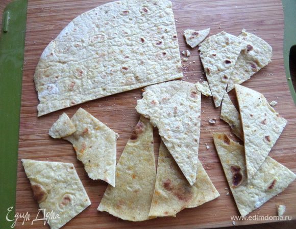 Для чипсов подсушить в духовке или на сковороде тортилью или лаваш, нарезать или поломать на кусочки.