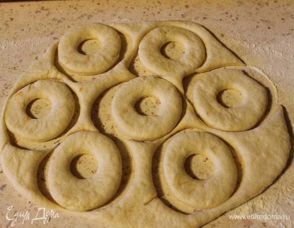 Тесто разделить на две части, для удобства раскатки. Раскатать одну часть в пласт примерно 3-4 мм, вырезать формочкой или стаканом фигурки, накрыть полотенцем и оставить на 20 минут для подхода. То же самое проделать с остальным тестом.