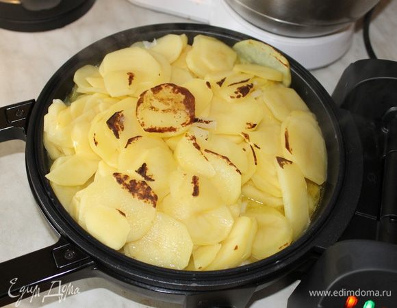 Картофель нарежьте тонкими ломтиками. Лук нашинкуйте мелким кубиком и вместе с картофелем выложите на сковороду. 