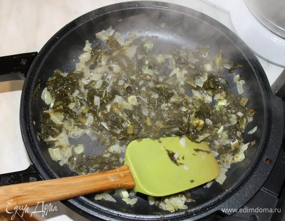 На другой сковороде приготовьте начинку из шпината. На сливочном масле поджарьте нарезанный кубиками лук и измельченный чеснок. Когда лук начнет менять цвет добавьте нарезанный шпинат и продолжайте готовить начинку не более 5 минут. Готовую начинку посолите и добавьте по вкусу перец.