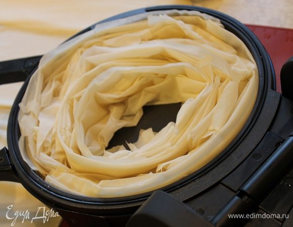 Листы теста сложите гармошкой и уложите по спирали в форму для выпечки. Отправьте тесто запекаться в горячую духовку до румяности. Я это делала в тортильнице. У нее крышка имеет нагрев и с закрытой крышкой прибор превращается в мини духовку.