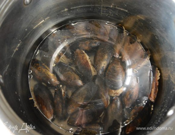 Сверху плотно прикрыть тарелкой, положить сверху груз, влить пол стакана или стакан воды (вода почти покрывает раковины мидий). Варить на сильном огне, пока не выпариться вся вода.