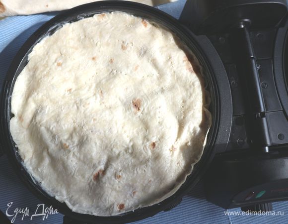 Прикрыть свисающими концами лаваша, если требуется — немного их подрезать, промазать смесью загнутый лаваш, накрыть кружочком лаваша, смазать смесью, наколоть в некоторых местах вилкой. Поставить температуру 170°С (3 уровень), время — 17 минут. Открыть после выключения, проверить, закрыть, не забудьте про защелку, которую надо закрывать при перевороте, перевернуть, потом защелку открыть. И еще 15 минут при той же температуре выпекать. Крышка может чуть приподняться за 10 минут до окончания выпечки. Это не страшно, ничего вытечь не должно. Начинка у вас герметично упакована в лаваш. 
