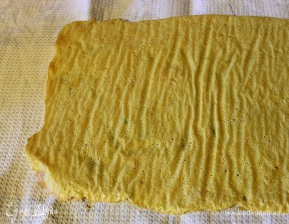 Готовый горячий рулет переложить на чистое полотенце, пергаментом вверх.
