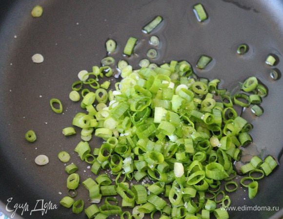 Зеленый лук нарезать кольцами, посолить и обжарить на 1 ст. л. растительного масла ровно 1 минуту.
