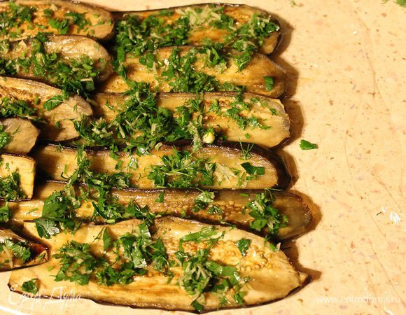 На столе расстелить пищевую пленку, сверху нее выложить ломтики баклажанов, 2 штуки в длину и 6 штук в ширину.