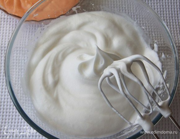 Яичные белки взбить с щепоткой соли до пышной пены, затем постепенно добавить оставшийся для бисквита сахар.