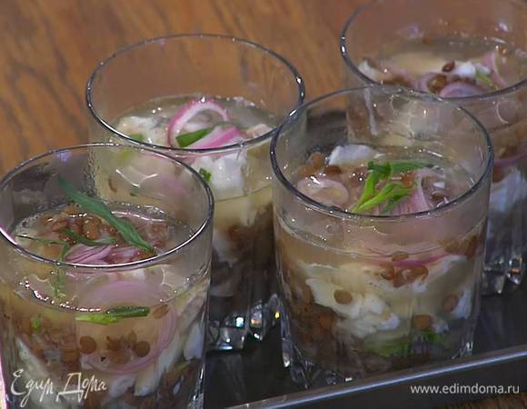 В прозрачные бокалы выложить по 1 ст. ложке чечевицы, немного рыбы, 3‒4 кольца замаринованного лука, затем еще немного чечевицы, залить все соусом с желатином, посыпать листьями оставшегося тархуна и отправить в холодильник на час.