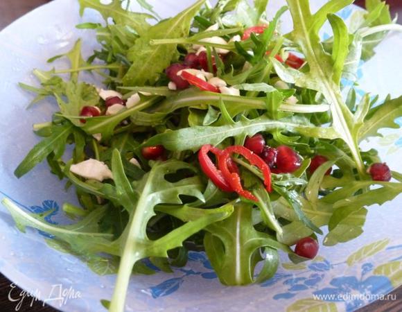 Миндаль подсушим в микроволновке и нарубим крупными кусками. Перец чили нарежем колечками. Смешаем руколу, перец, миндаль и зёрна граната. Заправим салат приготовленной заправкой. Аккуратно перемешаем.