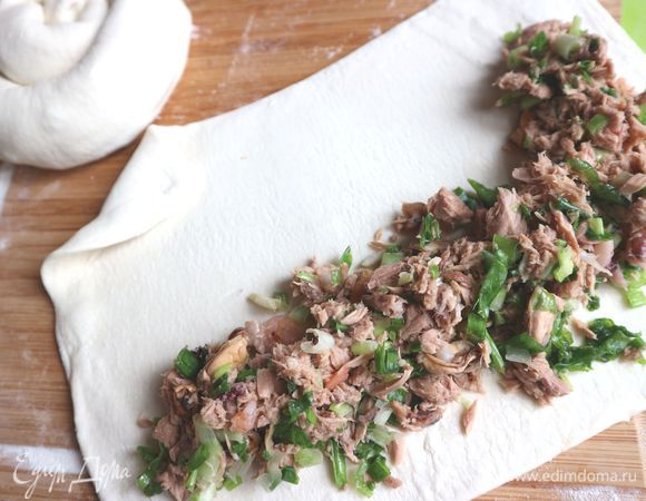 Из другой части, которую надо так же тонко раскатать, сделать основу для самой улитки. Положить рыбную начинку, придав ей необходимую форму, защипнуть края. 
