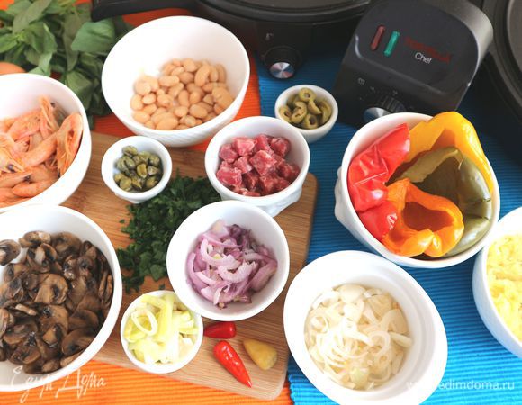 Оливки нарезать кружочками, креветки разогреть на паровой бане, почистить. Фасоль промыть, откинуть на сито. Болгарский перец (здесь разноцветный перец — красный, желтый, зеленый, оранжевый) запечь в духовке в фольге при температуре 200°C в течение 30 минут. Время и градус запекания я указываю для половинок перца четырех цветов. Меньшее количество запекать неудобно. У вас уйдет меньше перца, оставшийся можно использовать в другое блюдо. Из острого маринованного перца (маленький по размеру перец феферони) удалить семена. Зелень помыть, обсушить, измельчить. Чоризо нарезать кубиками.